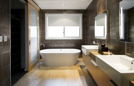 Australian Luxury bathroom with brown tiles and hardwood floor, focusing on a free standing bath. Clipping path around the windows and reflections in mirror/door.